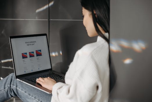 Woman sitting indoors using a laptop. Casual, modern tech vibe.