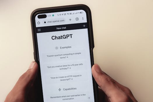 Close-up of hands holding a smartphone displaying the ChatGPT application interface on the screen.