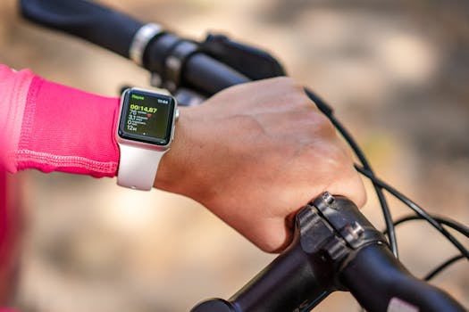 Cyclist checks smartwatch during bike ride. Focus on technology and fitness tracking.