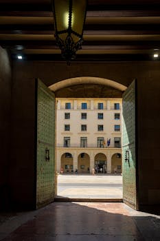 View through grand doorway to Alicante Provincial Courthouse on a sunny day.
